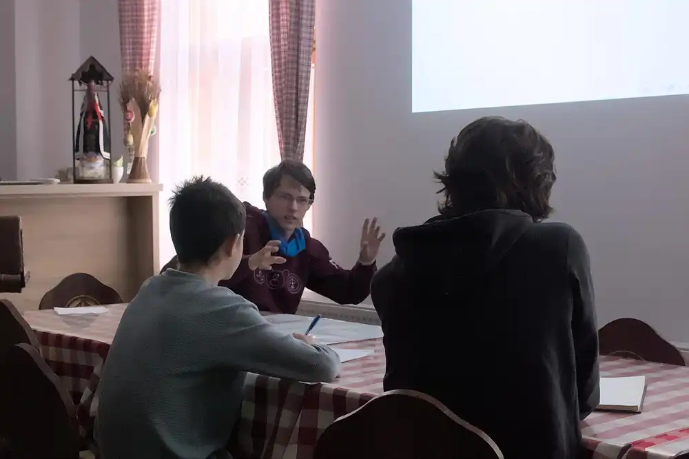 Účastníci sústredenia PRASK počas prednášky a diskusie pri stole