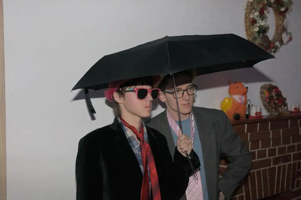 Vedúci sústredenia PRASK v dejovom oblečení stoja v interiéri pod otvoreným dáždnikom