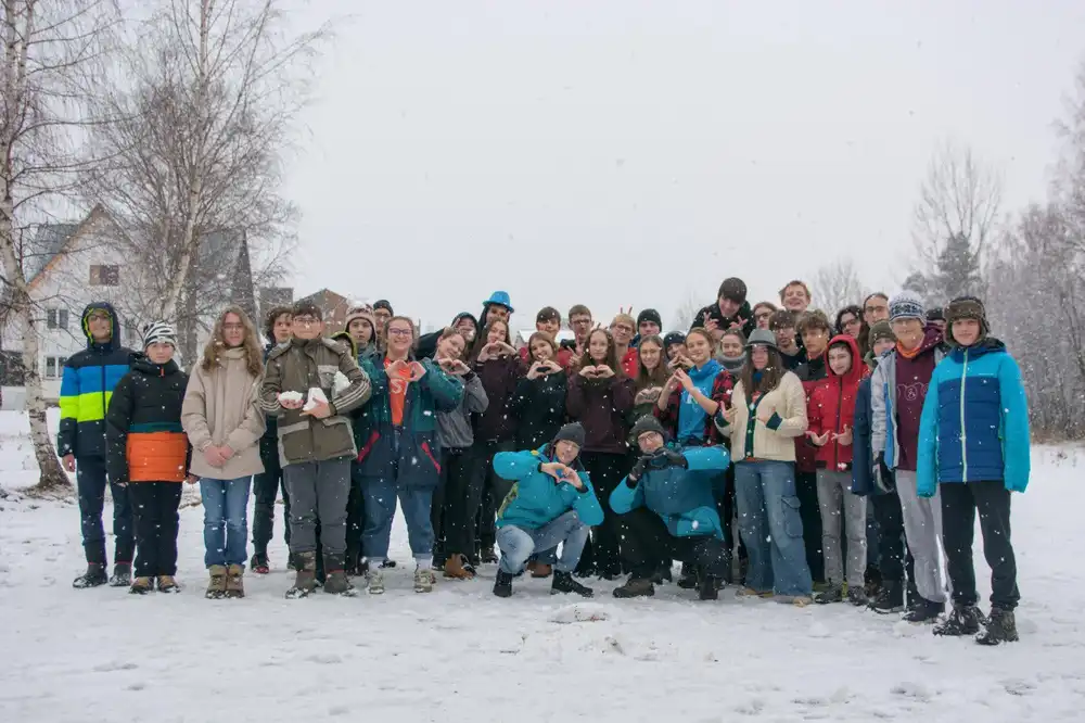 Skupinová fotografia účastníkov sústredenia PRASK vonku v padajúcom snehu